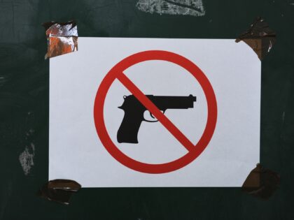 MITROVICA, KOSOVO - FEBRUARY A sign prohibiting guns on display at a polling station during the elections day in Mitrovica North to elect the Mayor on February 23, 2014 in Mitrovica, Kosovo. The candidate of the Civic Initiative Srpska, Goran Rakic, declared his victory after winning the mayoral elections in …