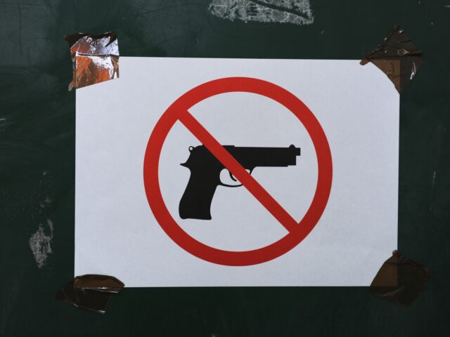 MITROVICA, KOSOVO - FEBRUARY A sign prohibiting guns on display at a polling station durin
