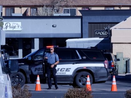 A police officer exits his car near a crime scene at a gay nightclub in Colorado Springs, Colo., Sunday, Nov. 20, 2022 where a shooting occurred late Saturday night. (AP Photo/Geneva Heffernan)