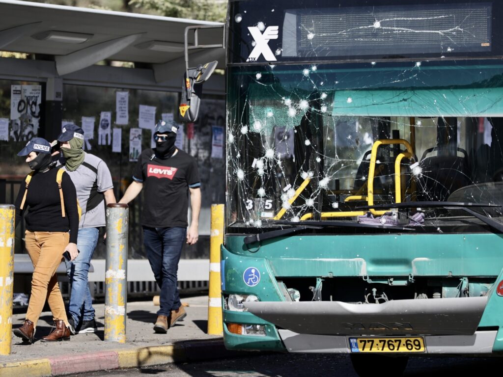 JERUSALEM - NOVEMBER 23: A damaged bus is seen as security forces inspect the area after two separate explosions that took place near the bus stop and at least 14 people were injured in West Jerusalem on November 23, 2022. The police suspect that the perpetrator arrived on an electric bike and placed the explosive device. (Photo by Mostafa Alkharouf/Anadolu Agency via Getty Images)