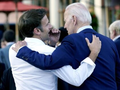 FILE - French President Emmanuel Macron whispers to U.S. President Joe Biden following the