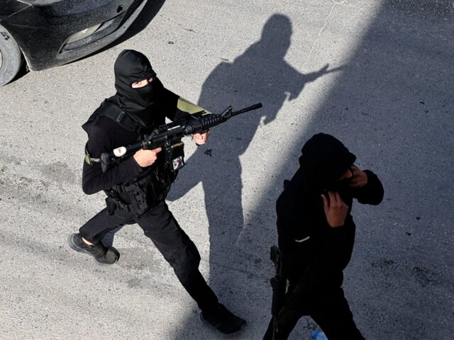 Palestinian gunmen attend the funeral of a youth who was reportedly killed during a raid b