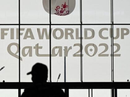 A policeman walks past a FIFA World Cup sign at the Qatar National Convention Center (QNCC