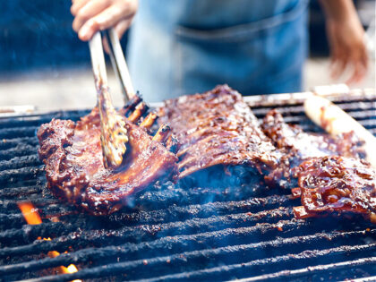 Barbecue pork ribs-grilled. A close up photo of a chef hands grilled a barbeque pork ribs.