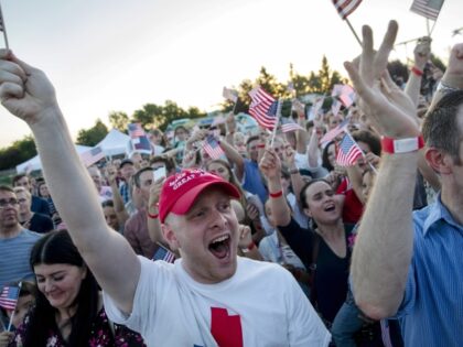 Attendees cheer and wave flags during an election night rally for Mitt Romney, Republican U.S Senate candidate, in Provo, Utah, U.S., on Tuesday, June 26, 2018. Romney won his partys Senate primary in Utah and advanced to the general election in November where the former Republican presidential nominee and sometimes …