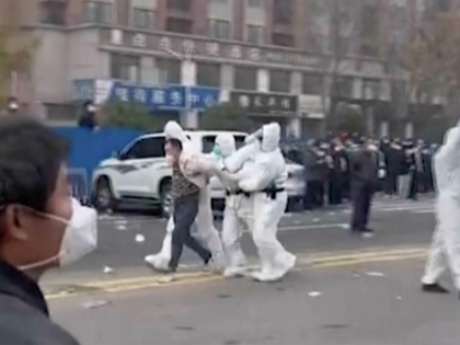 In this photo provided Nov 23, 2022, security personnel in protective clothing were seen taking away a person during protest at the factory compound operated by Foxconn Technology Group who runs the world's biggest Apple iPhone factory in Zhengzhou in central China's Henan province. Employees at the world's biggest Apple …