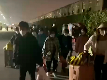 In this photo taken from video footage and released by Hangpai Xingyang, people with suitcases and bags are seen leaving from a Foxconn compound in Zhengzhou in central China's Henan Province on Oct. 29, 2022. Employees at the world's biggest Apple iPhone factory have been beaten and detained in protests …