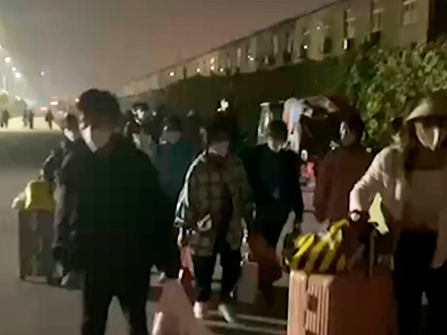 In this photo taken from video footage and released by Hangpai Xingyang, people with suitc