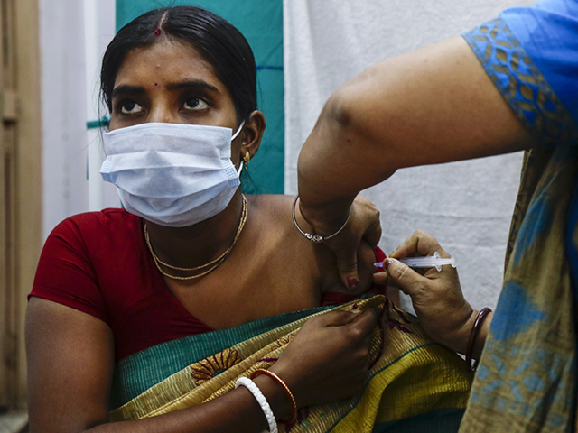 A health worker administers a dose of Covaxin COVID-19 vaccine at a health center in Garia