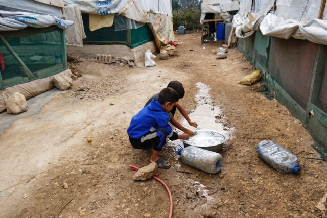 Amid an outbreak of cholera in the region, children rinse their hands at a camp for Syrian