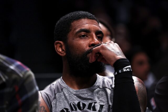 Brooklyn Nets star Kyrie Irving looks on from the bench during an NBA game against the Chi