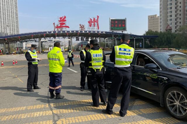 Police man a checkpoint in Lanzhou, which has been locked down for nearly a month