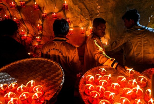 Revellers prepare lanterns to attach to hot-air balloons during the Tazaungdaing festival