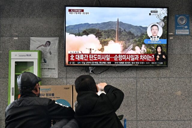 Visitors watch file footage of a North Korean missile test at the ferry terminal of South