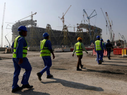 Workers walk to the Lusail Stadium, one of the 2022 World Cup stadiums, in Lusail, Qatar,