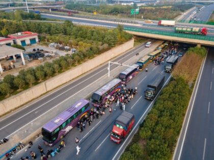 ZHENGZHOU, CHINA - OCTOBER 30: Foxconn employees take shuttle buses to head home on October 30, 2022 in Zhengzhou, Henan Province of China. Shuttle buses have been arranged by local authorities to facilitate the return trips of Foxconn factory workers to their hometowns after COVID-19 infections were reported in the …