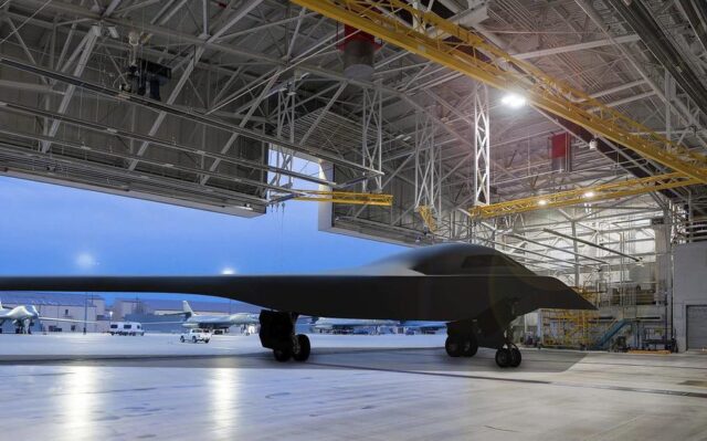 Artist rendering of a B-21 Raider in a hangar is seen with the background being Ellsworth