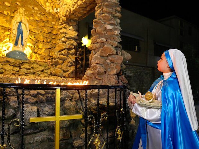 An Iraqi Christian woman prays during Christmas Eve Mass in St. Teresa's Church ahead of C