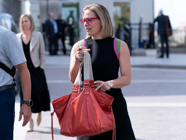 Sen. Kyrsten Sinema, D-Ariz., leaves after the Senate passed a short-term spending bill th