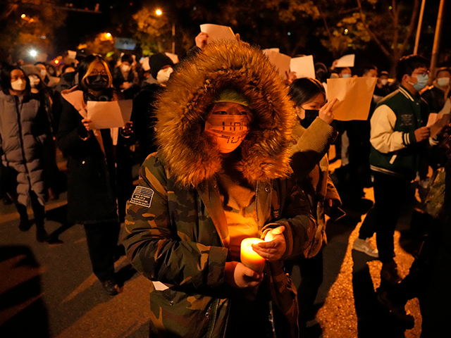 Protesters hold up blank papers and chant slogans as they march in protest against strict