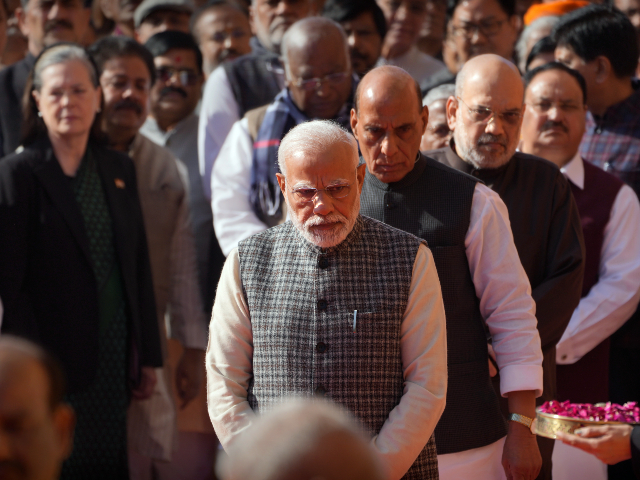 Indian Prime Minister Narendra Modi with his cabinet colleagues and other political leaders stand in a queue to offer floral tributes to the victims of 2001 terror attack on Parliament House, in New Delhi, Tuesday, Dec. 13, 2022. (AP Photo/Manish Swarup)