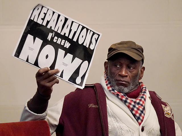 Morris Griffin holds up a sign during a meeting by the Task Force to Study and Develop Reparation Proposals for African Americans in Oakland, Calif., Wednesday, Dec. 14, 2022. (AP Photo/Jeff Chiu)