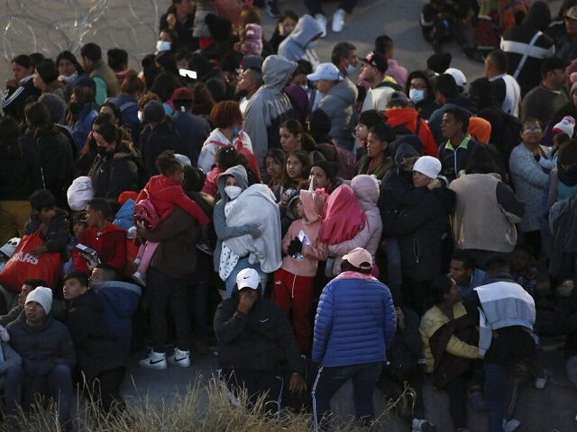 Migrants huddle in El Paso as temperatures fall to near freezing on Wednesday. (AP Photo/C