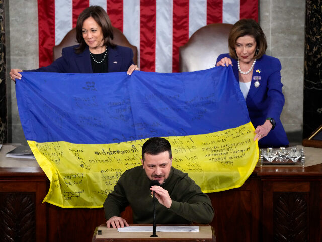 Vice President Kamala Harris and House Speaker Nancy Pelosi of Calif., right, hold up a Ukrainian flag autographed by front-line troops in Bakhmut, in Ukraine's contested Donetsk province, after Ukrainian President Volodymyr Zelenskyyas addressed a joint meeting of Congress on Capitol Hill in Washington, Wednesday, Dec. 21, 2022.(AP Photo/Jacquelyn Martin)