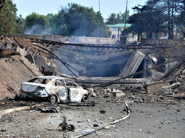 A burned out vehicle marks the spot where a gas tanker exploded under a bridge in Boksburg