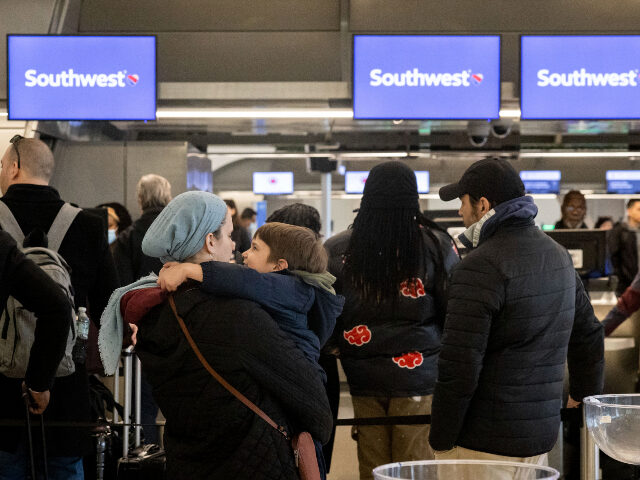 Passengers wait in line to check in for their flights at Southwest Airlines service desk at LaGuardia Airport, Tuesday, Dec. 27, 2022, in New York. The U.S. Department of Transportation says it will look into flight cancellations by Southwest that have left travelers stranded at airports across the country amid …