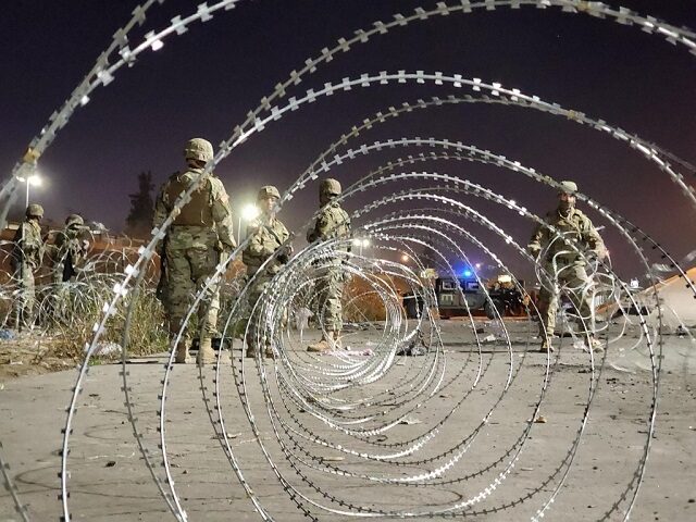 Texas National Guard soldiers build three-layer concertino wire fencing along the Rio Gran