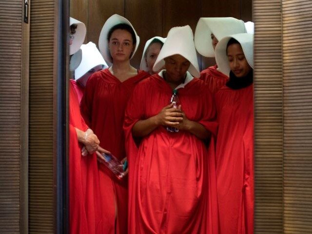 Women dressed as characters from the novel-turned-TV series "The Handmaid's Tale" stand in