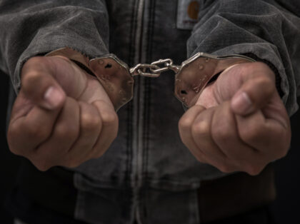 Upset handcuffed man imprisoned for financial crime, punished for serious fraud