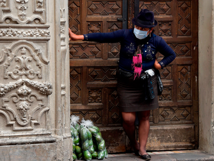 A street vendor wearing a face mask hides from the police in downtown Quito, on March 19, 2020. - Ecuador decreed state of emergency restricting the circulation of people against the spread of the new coronavirus. (Photo by RODRIGO BUENDIA / AFP) (Photo by RODRIGO BUENDIA/AFP via Getty Images)