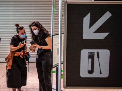 Passengers check mobile phones in El Prat airport, operated by Aena SA, in Barcelona, Spai