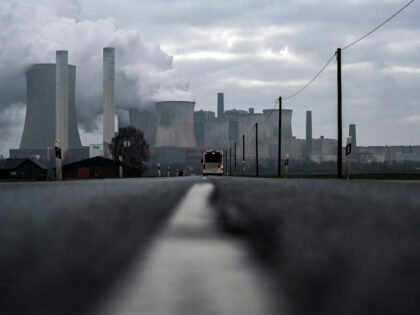 TOPSHOT - A bus drives on a road as steam rises from the cooling towers of the lignite-fir