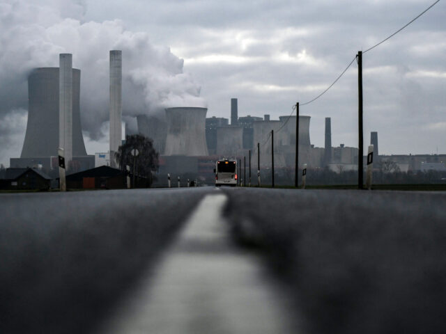 TOPSHOT - A bus drives on a road as steam rises from the cooling towers of the lignite-fired power plant of German energy giant RWE in Niederaussem, western Germany, on January 17, 2022. (Photo by Ina FASSBENDER / AFP) (Photo by INA FASSBENDER/AFP via Getty Images)