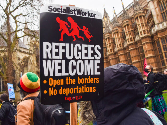 LONDON, UNITED KINGDOM - 2022/01/27: A demonstrator holds a 'Refugees Welcome' placard dur