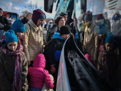 People are reflected on the windshield of a bus as they wait to be transported to Germany from the temporary shelter for refugees located in a former shopping center between the Ukrainian border and the Polish city of Przemysl, Poland, on March 8, 2022. - More than two million people …
