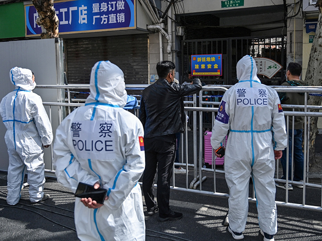 Police and officials wearing protective gear work in an area where barriers are being plac