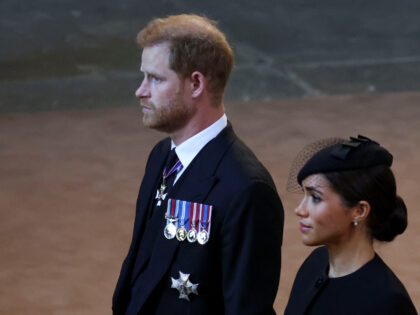 LONDON, ENGLAND - SEPTEMBER 14: Prince Harry and Meghan, Duchess of Sussex walk as procession with the coffin of Britain's Queen Elizabeth arrives at Westminster Hall from Buckingham Palace for her lying in state on September 14, 2022 in London, United Kingdom. Queen Elizabeth II's coffin is taken in procession …