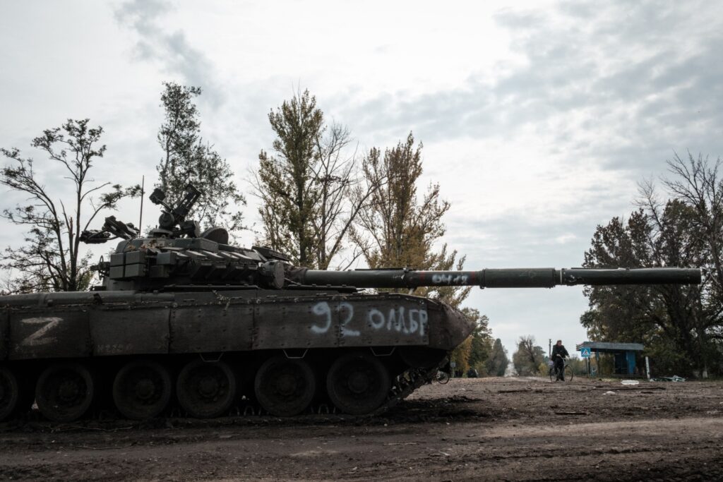 A local resident rides past an abandoned Russian tank marked Z in Kyrylivka, in the recently retaken area near Kharkiv, on September 30, 2022. (Photo by Yasuyoshi CHIBA / AFP) (Photo by YASUYOSHI CHIBA/AFP via Getty Images)