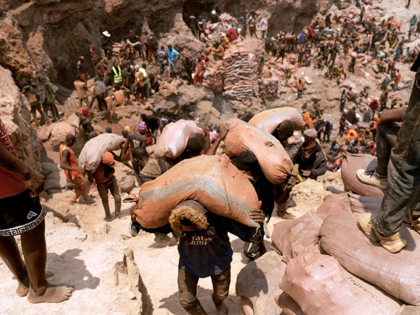 Artisanal miners carry sacks of ore at the Shabara artisanal mine near Kolwezi on October 12, 2022. - Some 20,000 people work at Shabara, in shifts of 5,000 at a time. Congo produced 72 percent of the worlds cobalt last year, according to Darton Commodities. And demand for the metal …