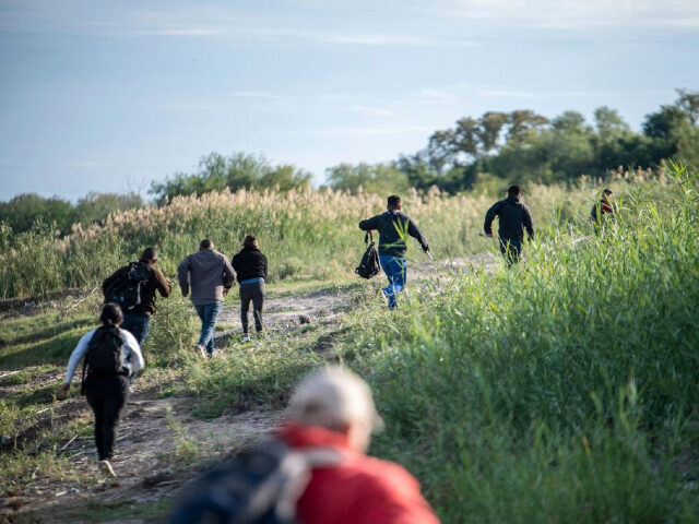 TOPSHOT - A group of migrants look for a place to cross the Rio Grande in Piedras Negras,