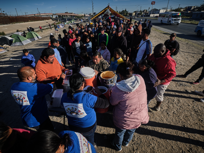 Venezuelan migrants get in line to receive donations of clothing and food at the camp area on the banks of the Rio Grande that divides Ciudad Juarez and El Paso Texas in Mexico on November 14, 2022. With more than 1,500 Venezuelan migrants camped on the banks of Rio Bravo …