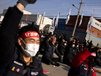 Truck drivers and members of the Korean Confederation of Trade Unions shout slogans during