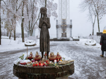 KYIV, UKRAINE - NOVEMBER 27: People visit the memorial to commemorate the victims of the Holodomor, a famine in Soviet Ukraine from 1932 to 1933 that killed millions of Ukrainians, despite the snow in Kyiv, Ukraine on November 27, 2022. (Photo by Andre Luis Alves/Anadolu Agency via Getty Images)