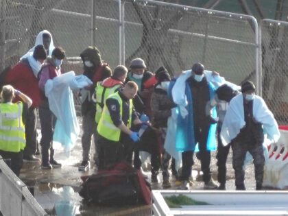 A group of people thought to be migrants are lead through the Border Force compound in Dov