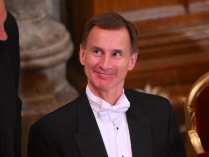 Britain's Chancellor of the Exchequer Jeremy Hunt (R) reacts during the Lord Mayor&#0