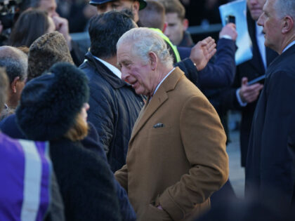 A close-protection officer (right) watches the crowd as King Charles III meets members of